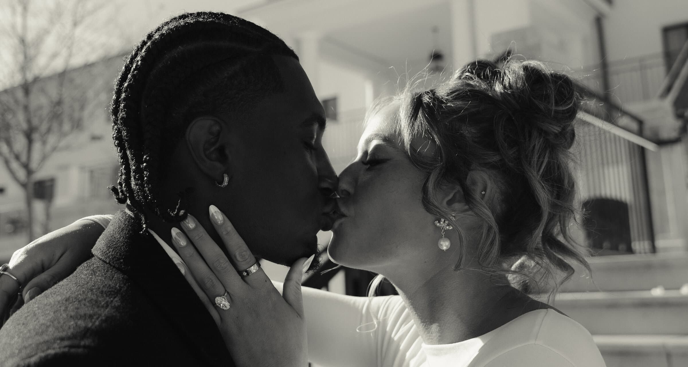 A black-and-white kiss during an engagement session