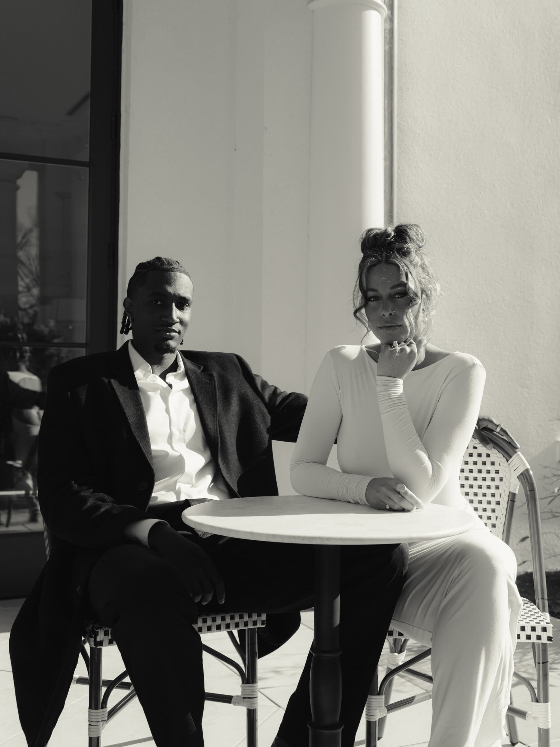 The couple seated together in black and white